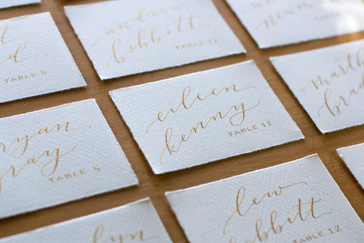 Gold calligraphy escort cards by Taryn Eklund Ink